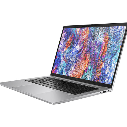 A refurbished HP ZBOOK FIREFLY 14 G11 A laptop by HP, featuring an AMD Ryzen 5 8640HS processor, is shown in silver with a colorful abstract display on its 14” FHD screen. The angled view from the left emphasizes the keyboard and multiple ports along the right edge. - View 4