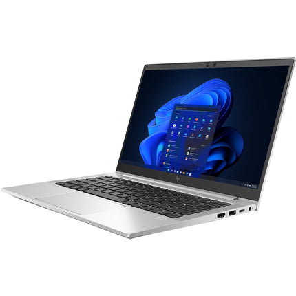 Angled view of a refurbished HP ProBook 630 G9 laptop, featuring a 13.3-inch display, visible black keyboard, and the Windows 11 home screen with vibrant blue wallpaper. The sleek silver device highlights its left-side ports and boasts an Intel Core i7-1265U processor, 32GB DDR4 RAM, and a 512GB NVMe SSD for modern performance. - View 5