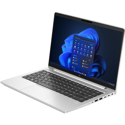 Angled view of a silver HP ProBook 640 G10 laptop by HP, displaying the Windows 11 home screen on its 14” FHD display with a black keyboard. This refurbished device features an Intel Core i5-1345U 1.6GHz processor, 32GB DDR4 RAM, and a 512GB NVMe SSD, with ports and part of the hinge clearly visible. - View 5