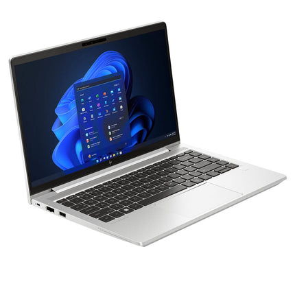 A silver HP ProBook 640 G10 refurbished laptop with a black keyboard is open and shown in an angled view, displaying the Windows 11 home screen on its 14” FHD display. Powered by an Intel Core i5-1345U 1.6GHz processor, 32GB DDR4 RAM, and a 512GB NVMe SSD, the laptop is positioned against a white background. - View 4