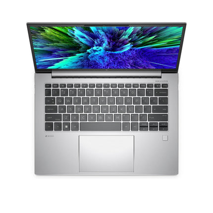 Top view of a refurbished HP ZBOOK FIREFLY 14 G10 A laptop, featuring a 14” FHD display, AMD Ryzen 5 7640HS processor at 4.3GHz, 16GB DDR4 RAM, and a 512GB NVMe SSD, with a black keyboard and a vibrant blue and green abstract image on the screen. - View 2